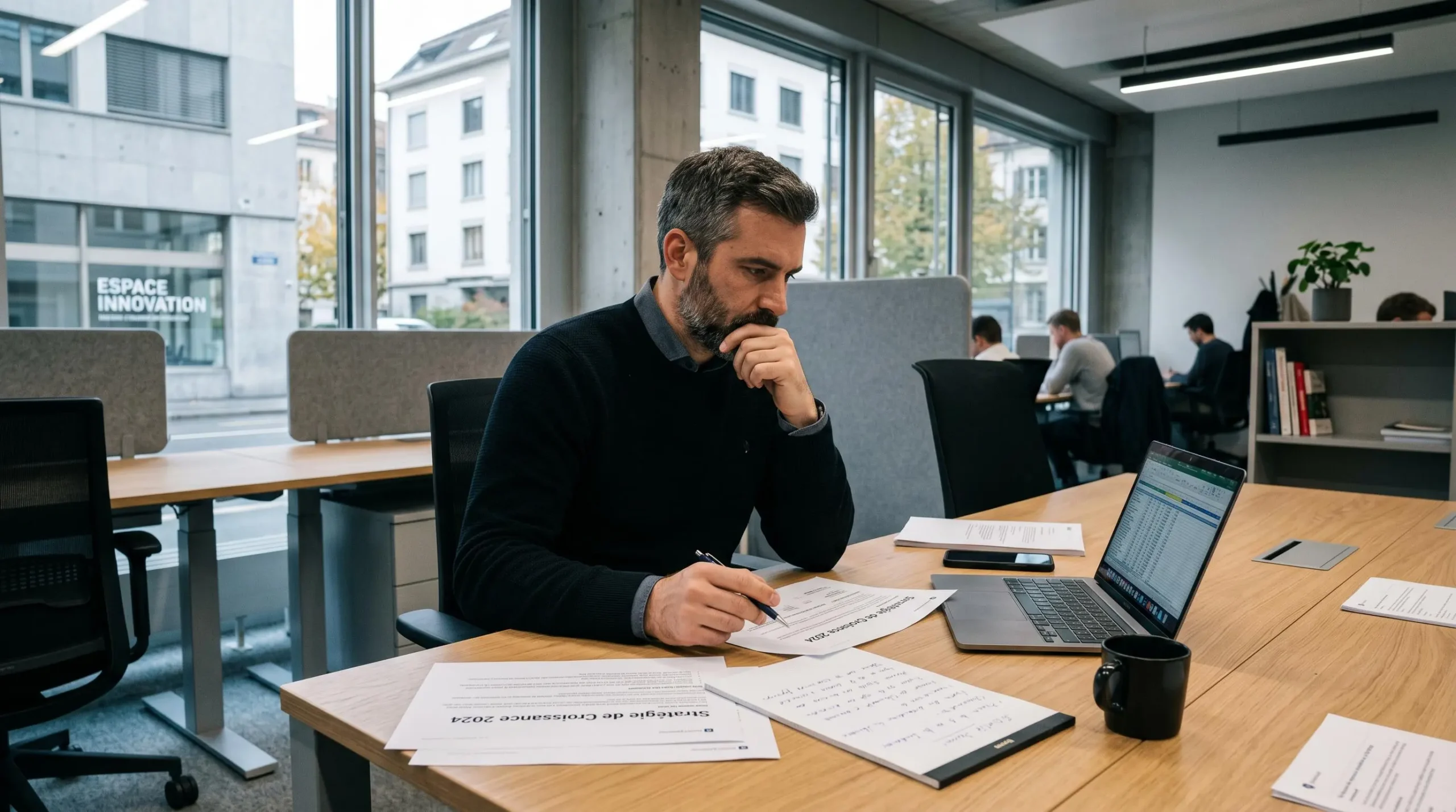 Fondateur startup en réflexion stratégique avec documents de planification dans bureau moderne