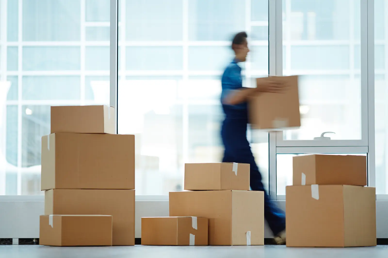 Entrepreneur comparant différents types de caisses en carton adaptés au poids et à la fragilité des produits.